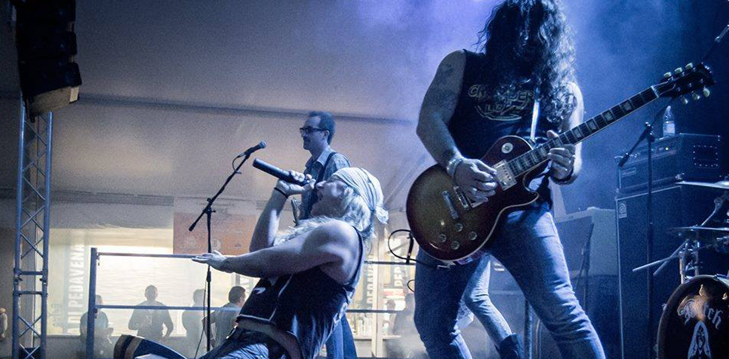 Zanger en gitarist tijdens een live tributeshow in blauw podiumlicht